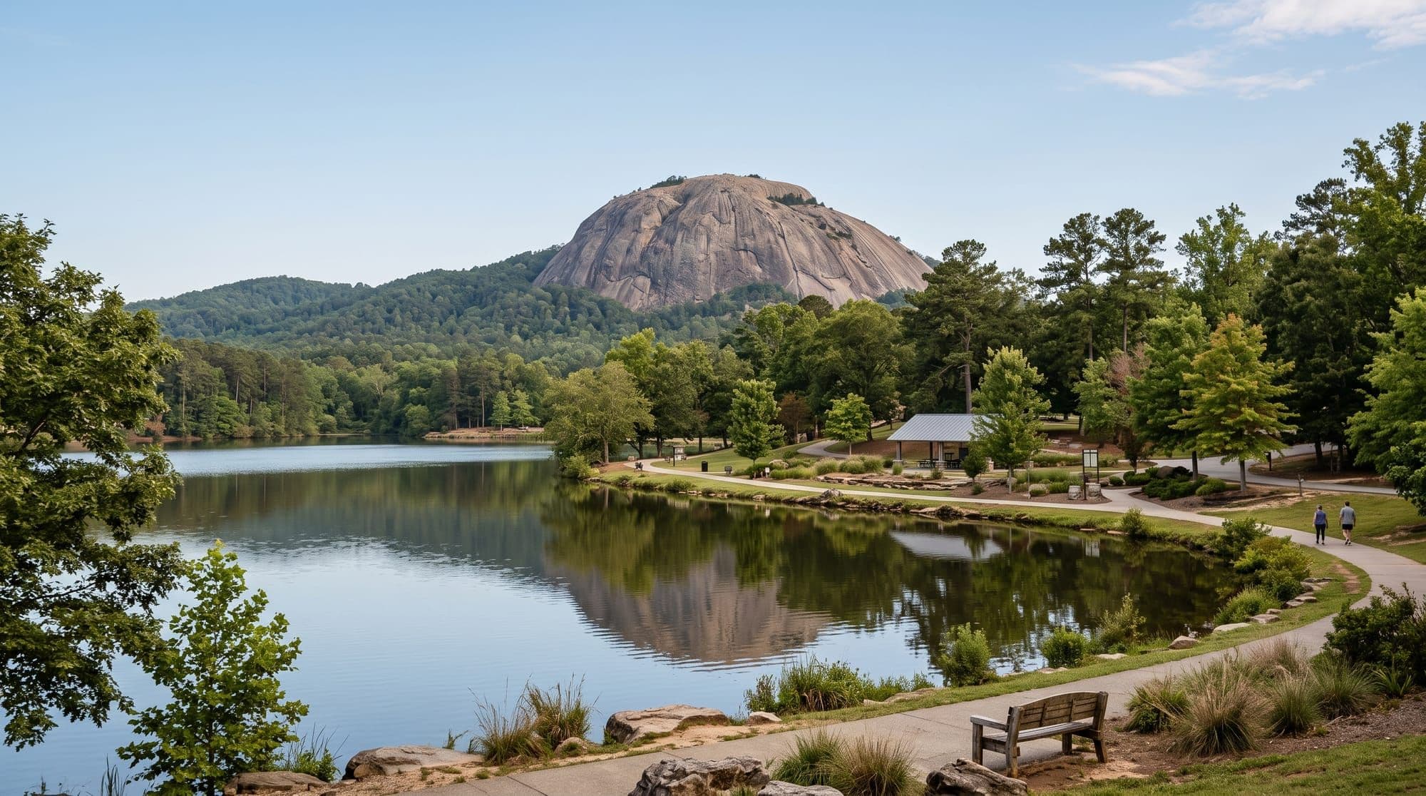 Granite mountain dome rising above a calm lake and tree-lined shoreline