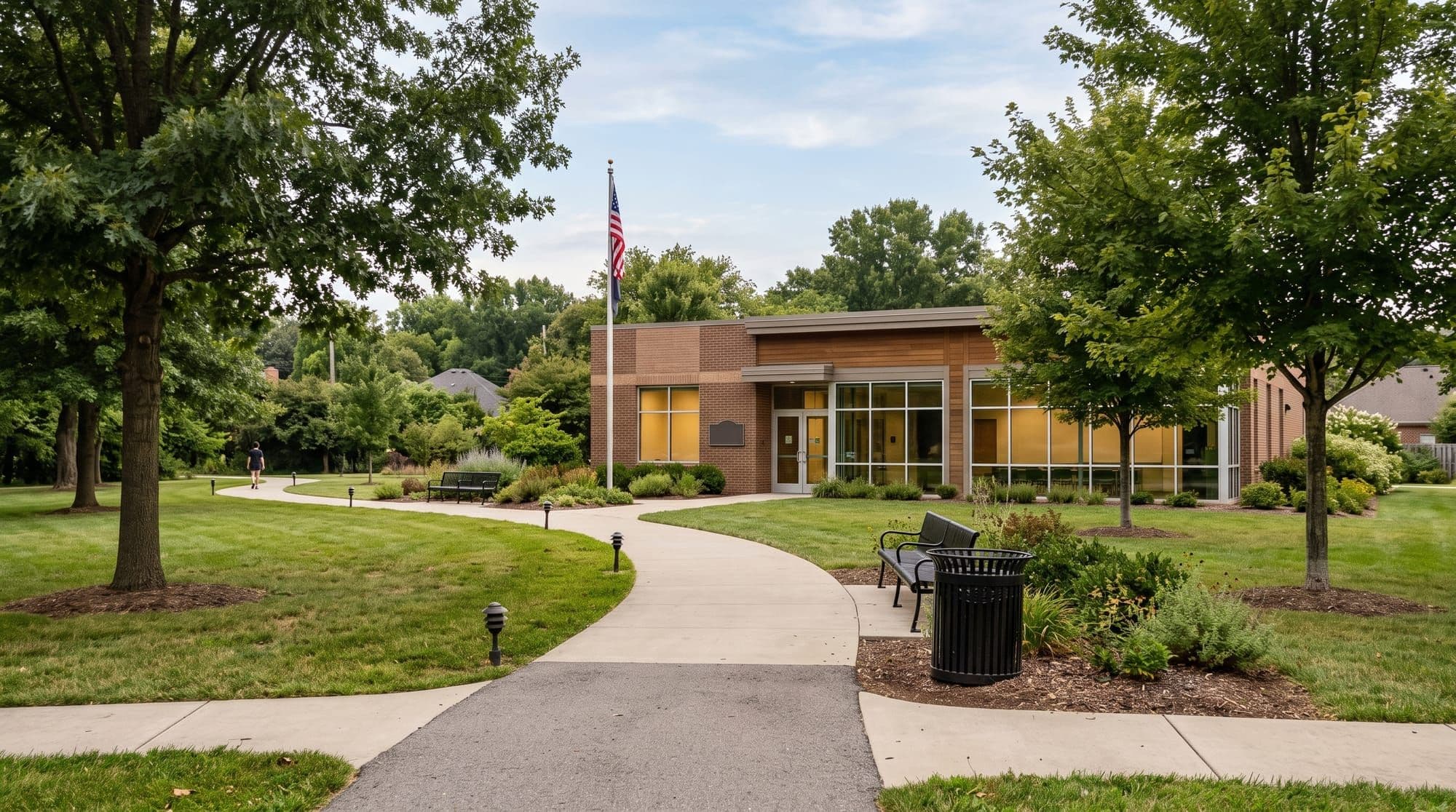 Modern community center building fronting a landscaped park lawn